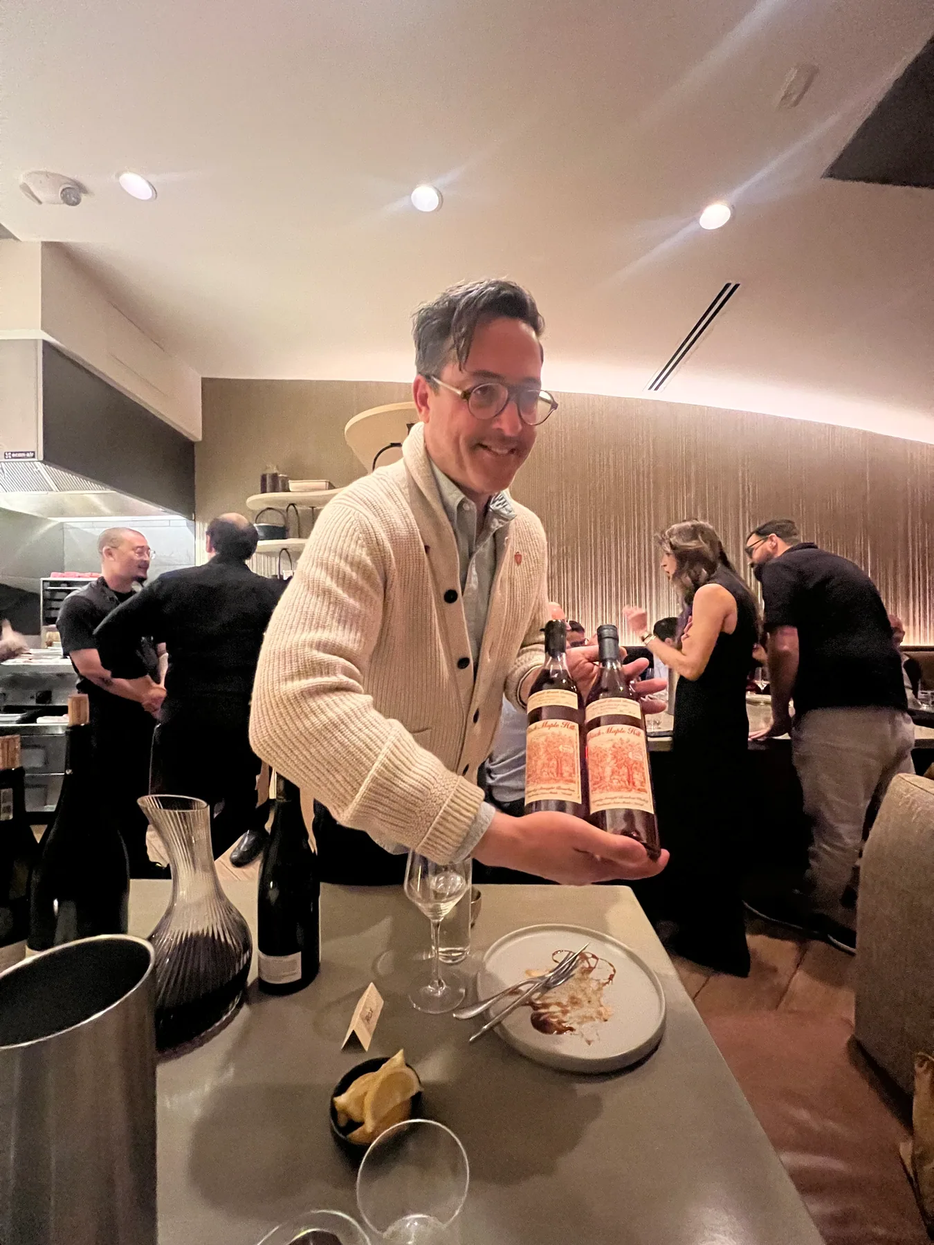 A host presenting bottles to guests at a tasting event