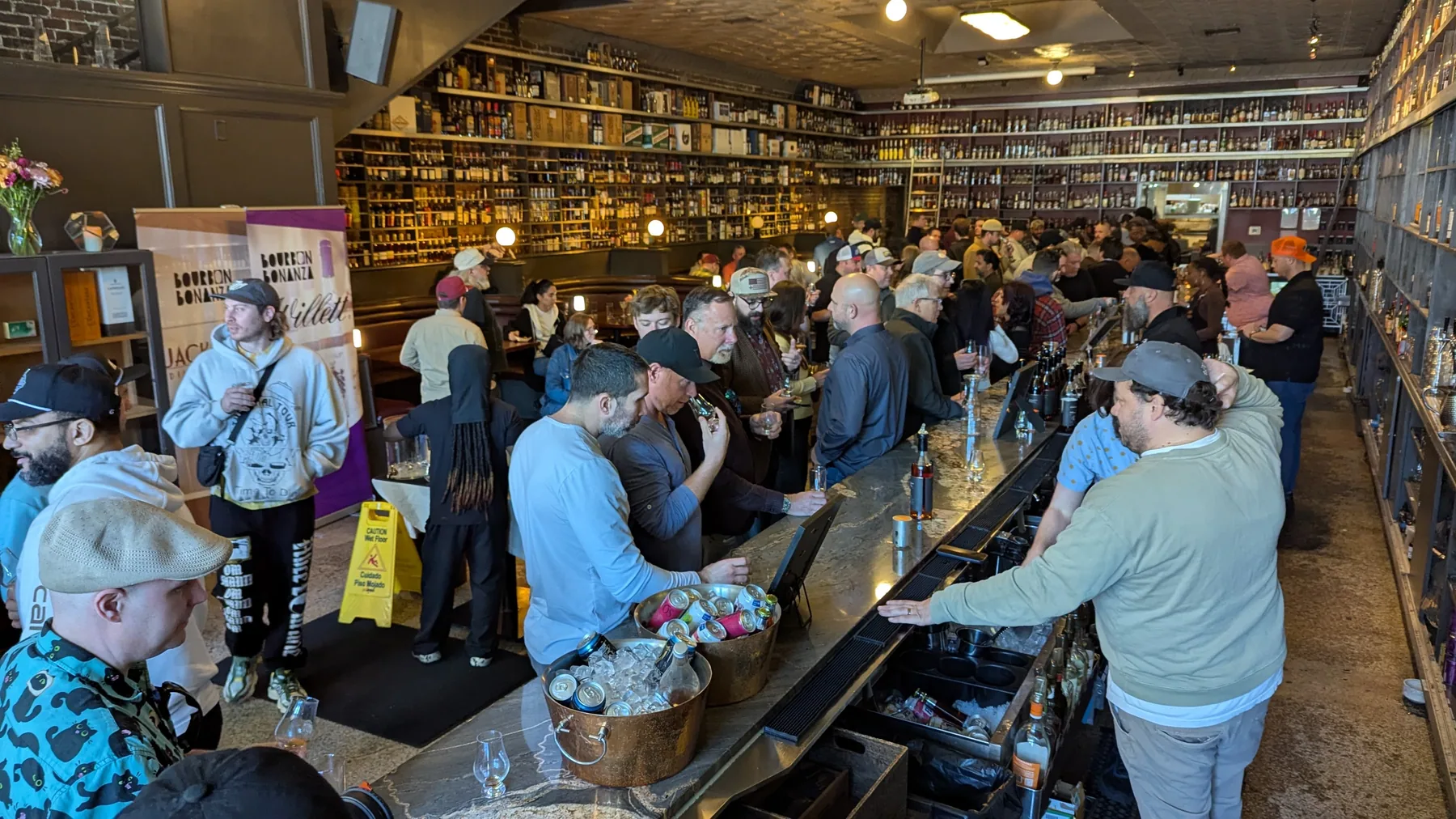 A crowd gathered inside a distillery event space