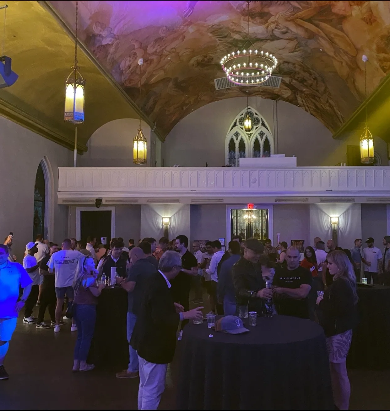 An evening crowd gathered outside a lit historic venue
