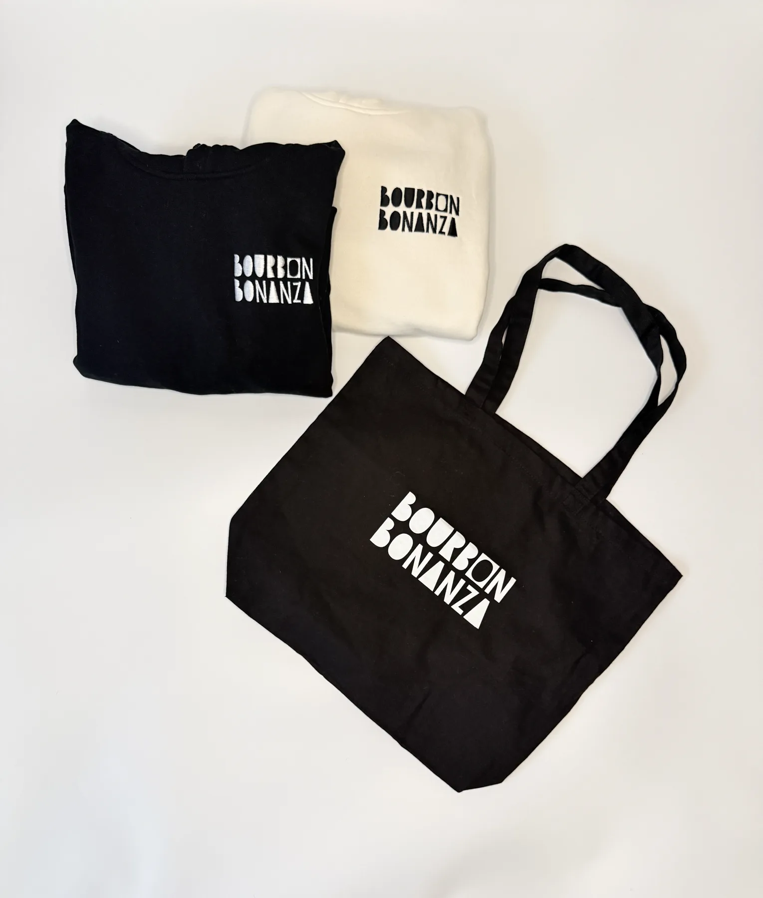 Folded Bourbon Bonanza shirts with a branded black tote bag