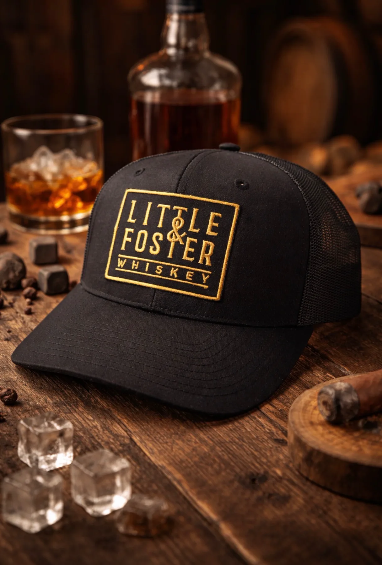 Little and Foster Whiskey cap staged with a whiskey bottle and glass