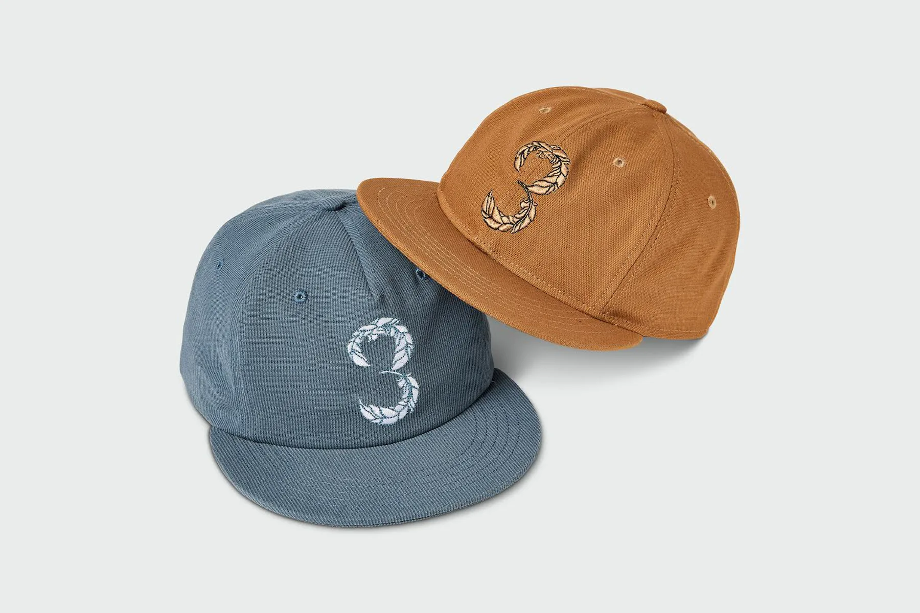 Blue and gold caps embroidered with the 3 Feathers mark